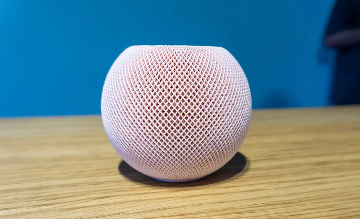 هوم پاد مینی 2؛ اسپیکر پیشفرض مکهای سازگار اسپیکر صورتی HomePod mini روی میز چوبی