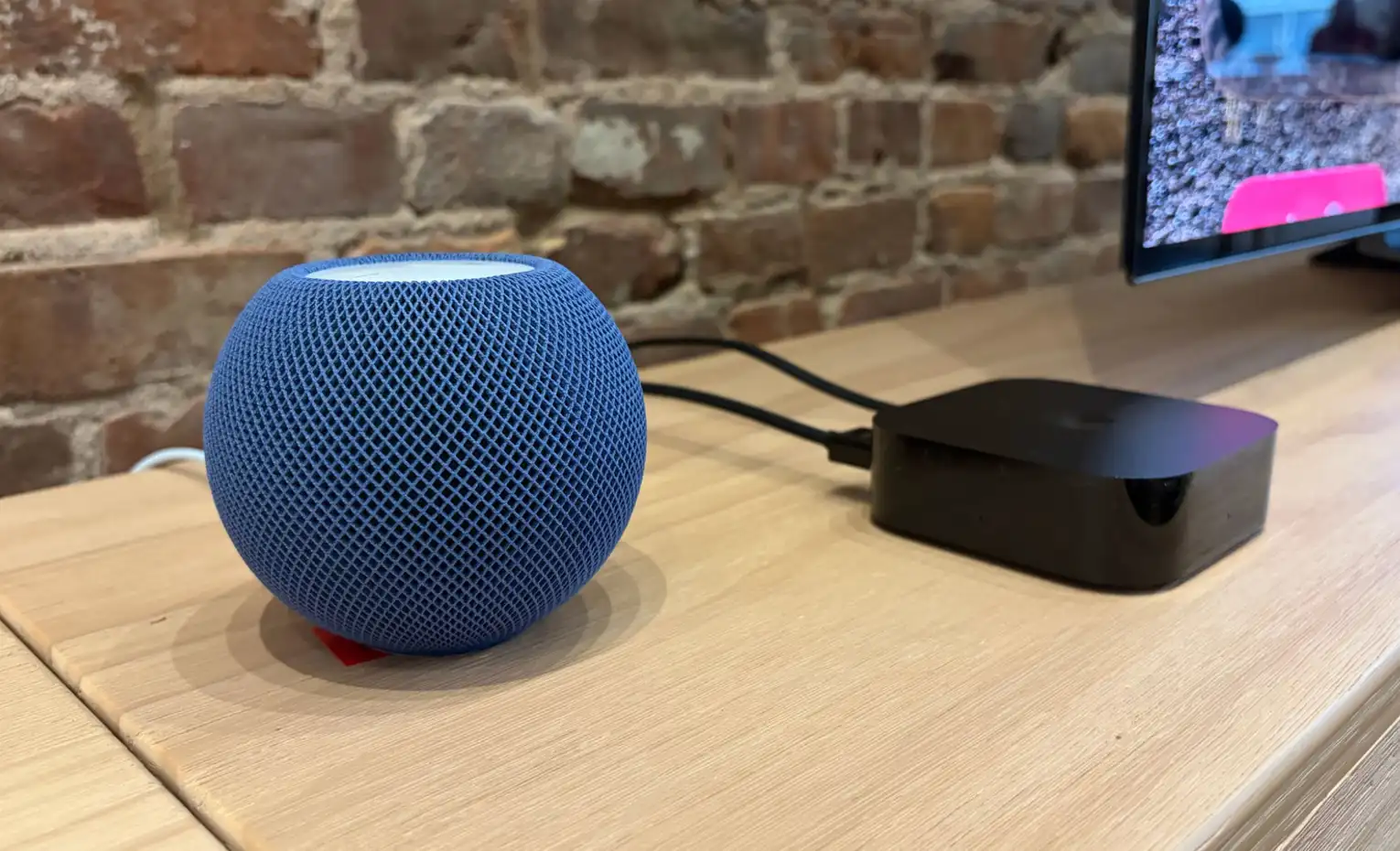 هوم پاد مینی 2؛ اسپیکر پیشفرض مکهای سازگار اسپیکر آبی HomePod mini کنار مک مینی و نمایشگر