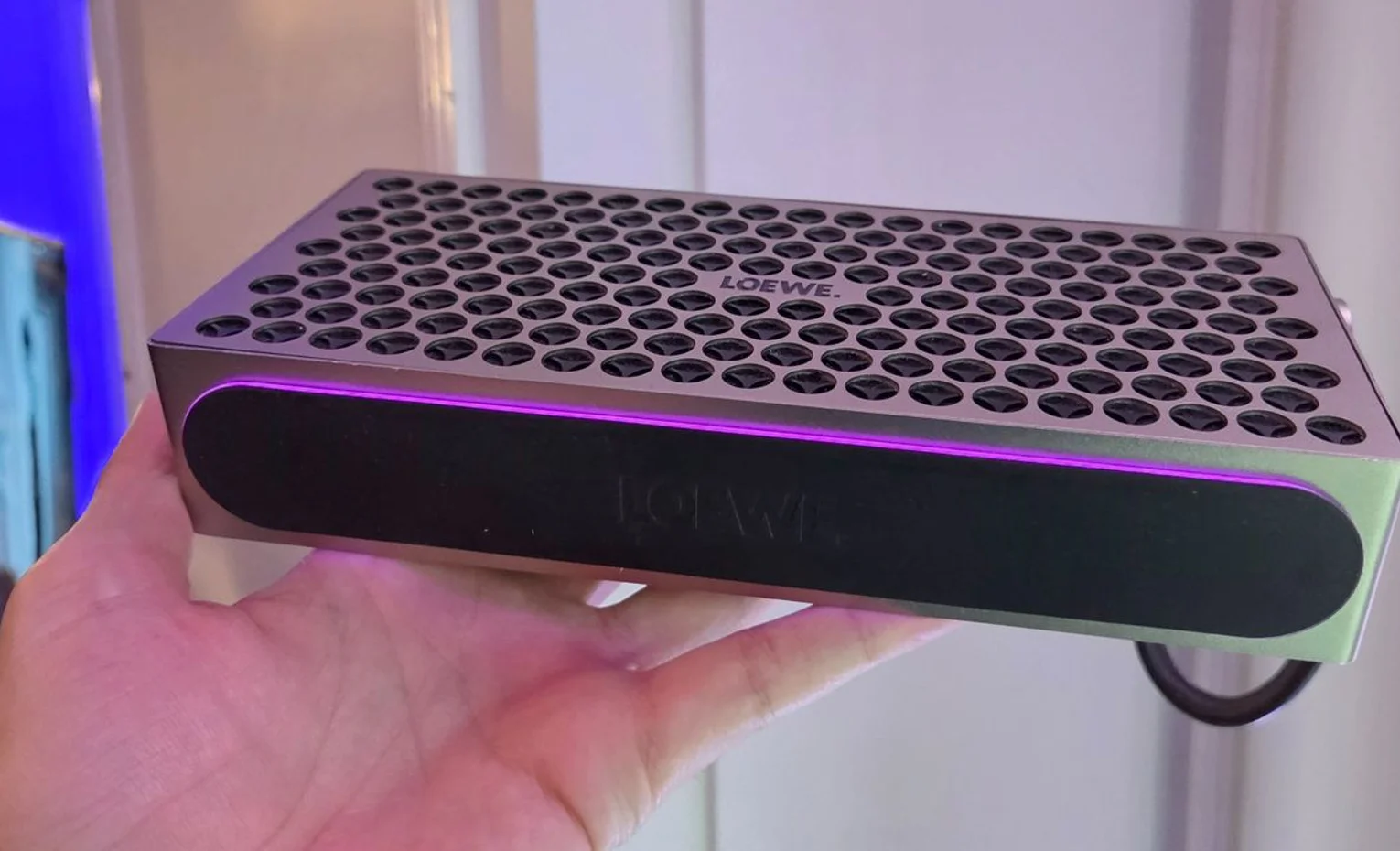 اسپیکر بلوتوثی Loewe Neo با طراحی لوکس و توان 50وات معرفی شد نمای سطح مشبک و لبه نورانی Loewe Neo در دست کاربر