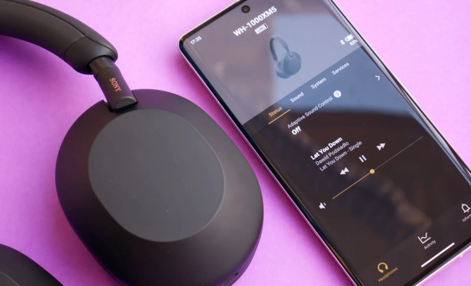 شنیدن صدای محیط با هدفون نویز کنسلینگ سونی WH-1000XM5 هدفون مشکی سونی کنار گوشی با صفحه تنظیمات هدفون