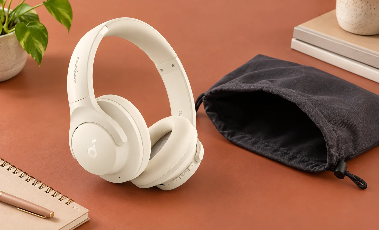 زرد شدن هدفون سفید؛ قبل از خرید چه بدانیم؟ هدفون روشن Soundcore کنار کیسه حمل مشکی روی میز