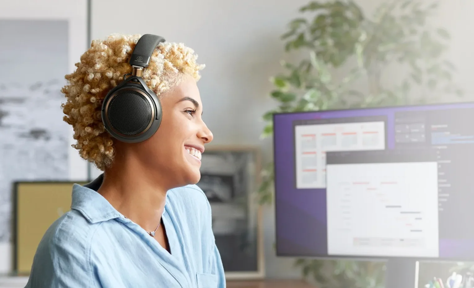 Audio-Technica ATH-AL5NC، هدفون پشتباز با نویزکنسلینگ فعال کاربر با هدفون Audio-Technica پشت میز رایانه