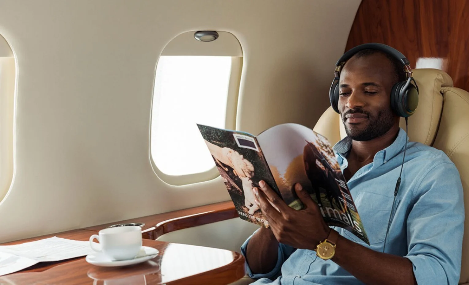 Audio-Technica ATH-AL5NC، هدفون پشتباز با نویزکنسلینگ فعال مسافر با هدفون Audio-Technica در حال مطالعه در هواپیما